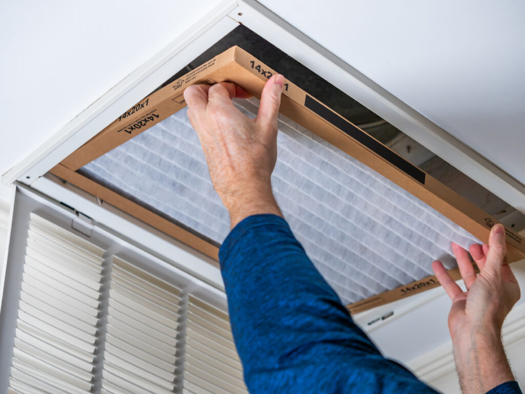HVAC technician replacing a home air filter in Folsom