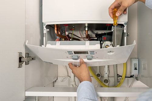 Heating technician repairing a residential boiler in Folsom