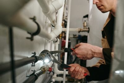 Technician inspecting commercial plumbing pipes in Folsom