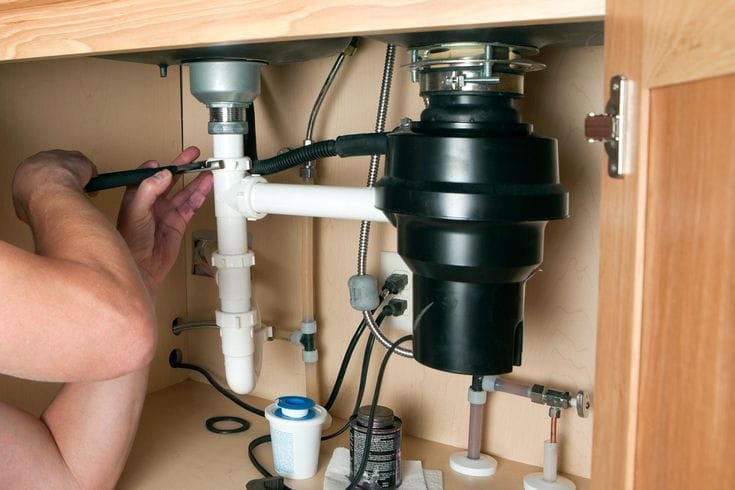 Plumber repairing a garbage disposal in Folsom