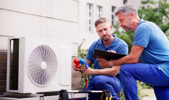 HVAC technicians installing an outdoor air conditioning unit in Folsom
