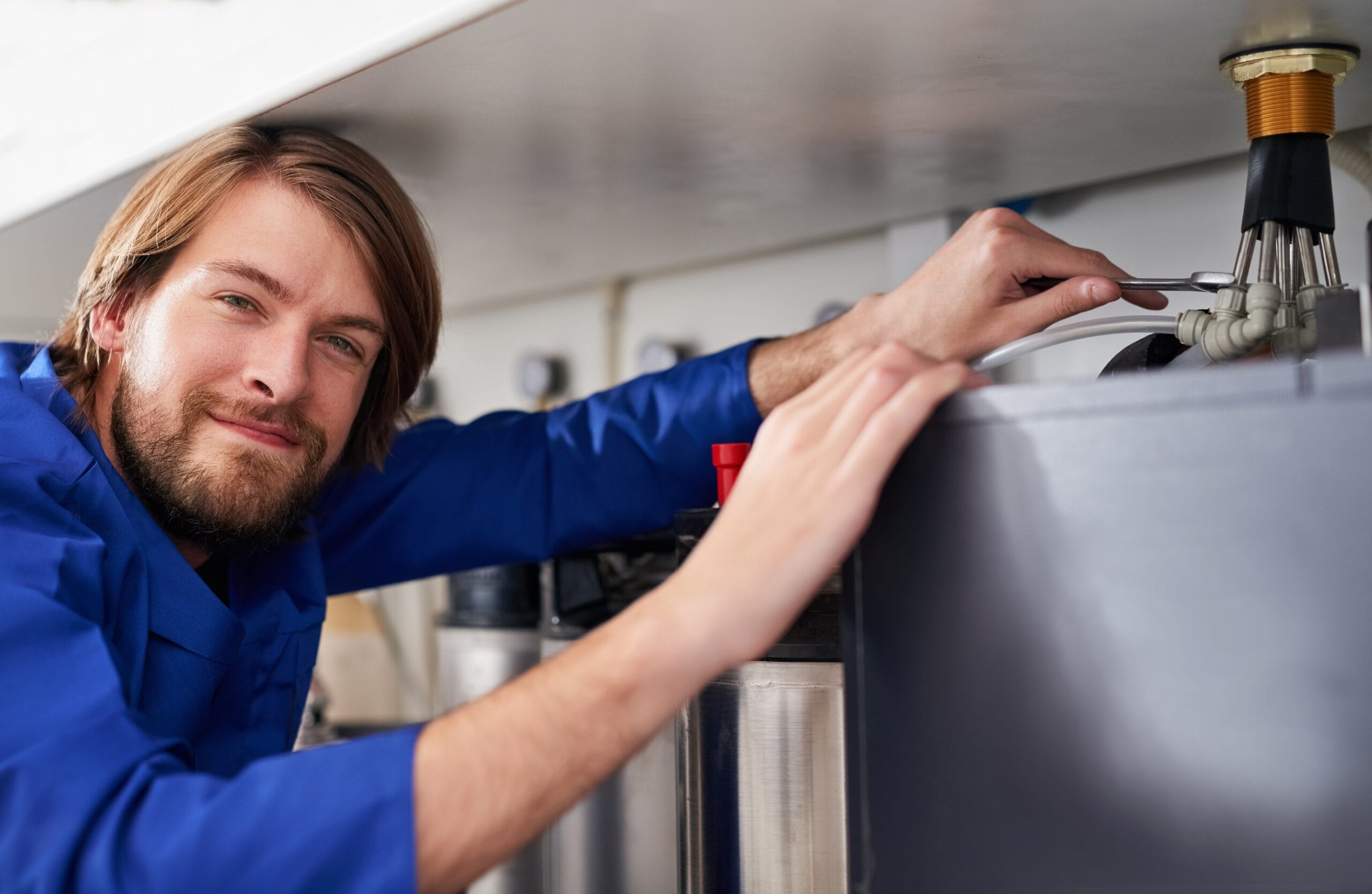 Technician servicing a residential water heater tank in Folsom